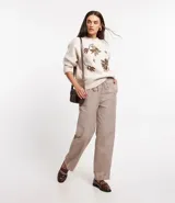 Pantalón jogger de tricolina color beige con estampado de cuadros, cintura elástica con lazo y bolsillos laterales.