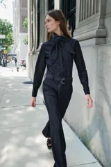 Pantalón de jean azul oscuro, corte wide leg, tiro alto, con cinturón de la misma tela y hebilla metálica.