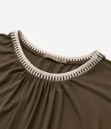 Vestido corto color verde oliva, confeccionado en crepé de viscosa sostenible. Tiene mangas cortas, cuello redondo de punto contrastante, detalle fruncido y lazo en la cintura.