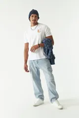 Remera blanca de manga corta con cuello redondo y estampado con flores y texto en tonos marrones.