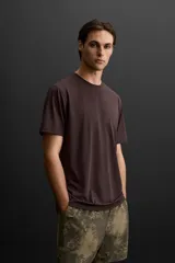 Camiseta deportiva marrón de tejido técnico ligero y elástico con estructura. Cuello redondo, manga corta, costuras planas y logo estampado.