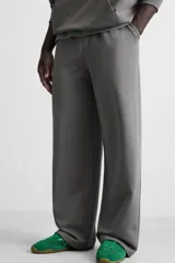 Pantalón jogger negro de corte ancho, confeccionado en tejido de algodón con interior de rizo. Cuenta con cintura elástica ajustable con cordón interior, bolsillos laterales y bolsillo trasero de parche.