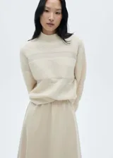 Sweater color crema con cuello perkins y paneles en contraste.