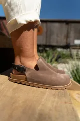 Zuecos de cuero marrón con talón descubierto y suela de goma.