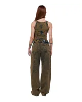 Pantalón unisex de denim 100% algodón con acabado marmolado color bronce. De tiro medio y calce wide/relajado, con pierna muy amplia y caída larga. Cintura con elásticos laterales, costuras curvas y bolsillos delanteros y traseros con bocas redondeadas.