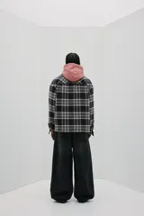 Sobrecamisa de franela de algodón a cuadros blancos, negros y grises. Corte oversized, cuello inglés, tapeta con botones a presión, canesú en la espalda, bolsillos superiores con solapa y botón a presión, bolsillos laterales y bajo recto con aberturas laterales. Mangas largas con tapeta y botón a presión en los puños. Forro guateado.