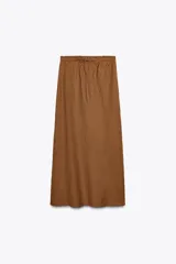 Falda midi color marrón confeccionada en lino 100%. Tiene tiro medio, cintura elástica ajustable con cordones y bajo evasé.