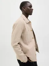 Blazer color beige de lino y algodón, corte slim fit, con solapa clásica, cierre con botón, bolsillo en el pecho y tejido plano resistente.