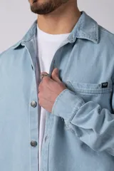 Chaqueta de jean celeste de corte recto, con cuello clásico, cierre frontal con botones metálicos y bolsillo de parche en el pecho.