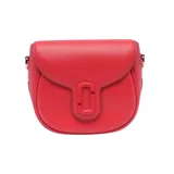 Bolso saddle pequeño de cuero color rojo, con solapa y cierre magnético. Presenta el logo de la marca en relieve en el frente y herrajes dorados. Incluye correa de cuero ajustable y correa de tela con logo de la marca.
