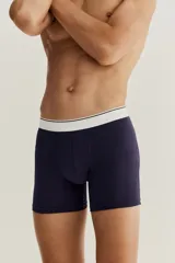 Pack de tres calzoncillos tipo trunk en punto elástico de algodón, color gris, blanco y azul marino, con cintura elástica blanca con una fina línea negra. Confeccionados con la tecnología Lycra® Xtra Life™.