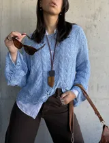 Sweater celeste de hilo con calados y mangas largas acampanadas.