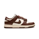 Zapatillas Nike Dunk Low, color blanco y marrón chocolate, con cordones marrones y suela color crema.