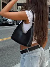 Cartera negra de ecocuero con diseño estructurado y asa corta.