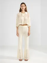 Camisa corta italiana confeccionada en punto abierto de algodón color crema, con cuello clásico, cierre frontal con botones y mangas cortas.