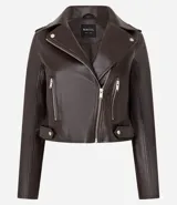 Campera biker marrón de cuero sintético con cuello con solapa, cierre frontal asimétrico con cremallera, bolsillos con cremallera y tiras con botones en los laterales.