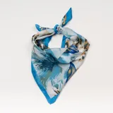 Pañuelo cuadrado de seda con estampado abstracto en tonos celeste, azul, blanco y ocre.