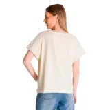 Remera color crema de corte holgado con estampado frontal de la marca Caterpillar en verde y rosa.