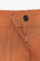 Pantalón color crema de tiro alto con pinzas delanteras y cintura elástica en la espalda. Tiene bolsillos delanteros y traseros.