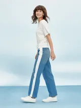 Pantalón de jean azul con cintura blanca y raya blanca lateral.
