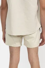 Short de baño color crema con tira lateral color borgoña y cordón de ajuste en la cintura.