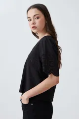Blusa color crudo de broderie con escote en V y cierre frontal con lazos.