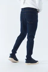 Pantalón de jean gris oscuro, corte carrot, tiro medio, con logo bordado y presillas para cinturón.