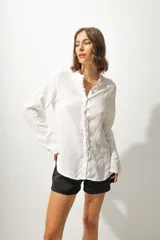 Camisa blanca de lino con cuello mao y cierre frontal con botones.