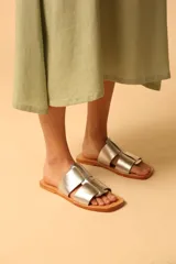 Sandalias plateadas con tiras anchas entrecruzadas y suela plana color camel.