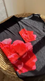 Conjunto de top corto y falda larga de tul negro con estampado de flores rojas.