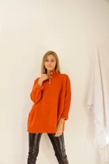 Sweater color ocre de lana de cordero con cuello alto abotonado y calce oversize.