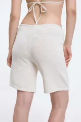 Short color blanco con textura de toalla y cordón ajustable en la cintura.