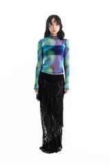 Remera de mangas largas de tul con cuello alto y estampado abstracto en tonos verdes, azules y violetas.
