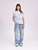 Remera celeste de algodón con estampado de flor y texto "Real View".
