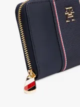 Billetera Tommy Hilfiger azul marino con cierre de cremallera, detalle de tejido trenzado, múltiples ranuras interiores para tarjetas, compartimento interior con cremallera e insignia del monograma TH dorada en la parte delantera.