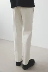 Pantalón de vestir color crema, de corte recto, con bolsillos laterales y traseros. Se ajusta a la cintura con botón.