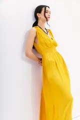 Vestido largo color mostaza, con escote en V, sin mangas y cintura elastizada con lazo.