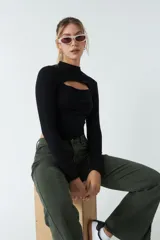 Top blanco de manga larga con cuello alto y abertura en el pecho. Corte ajustado y tejido elastizado.