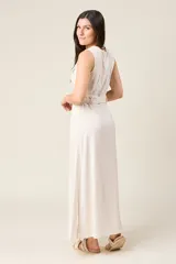 Vestido camisero largo sin mangas color negro, con cuello en V y cierre de botones delanteros. Incluye cinturón ancho a tono y bolsillos estilo safari en el pecho.