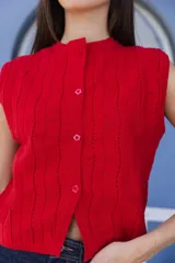 Chaleco tejido negro con botones en la delantera y diseño de punto acanalado.