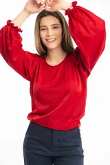 Blusa azul marino con cuello bote y mangas amplias con elástico en los puños.