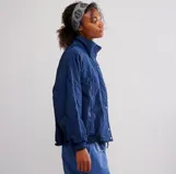 Chaqueta tipo bomber azul marino, con cuello alto y forro interior de piel sintética color verde lima. Presenta cierre frontal con broches y cremallera, y puños y cintura elásticos.