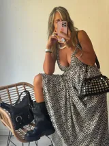 Vestido largo estampado animal print, con escote pronunciado en V y tirantes finos. La falda es amplia y fluida.