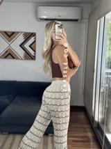 Pantalón de hilo color marrón con rayas horizontales blancas, corte holgado y cintura con cordón ajustable.