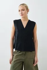 Musculosa negra con escote en V y bordado floral en el frente. Sin mangas y corte recto.