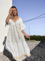 Vestido túnica largo de color celeste con bordados dorados y detalles de encaje en el escote y ruedo.