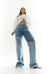 Pantalón de jean con diseño patchwork en diferentes tonos de azul, corte recto y tiro alto.