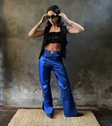 Pantalón de cuero azul con corte jean, tiro medio-alto y abertura lateral en el ruedo.