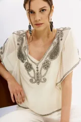 Blusa color crema de georgette con bordado de piedras, mostacillas y canutillos. Tiene viso interior con puntilla.