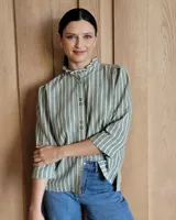 Camisa blanca de mangas 3/4 con cuello mao y botones frontales.